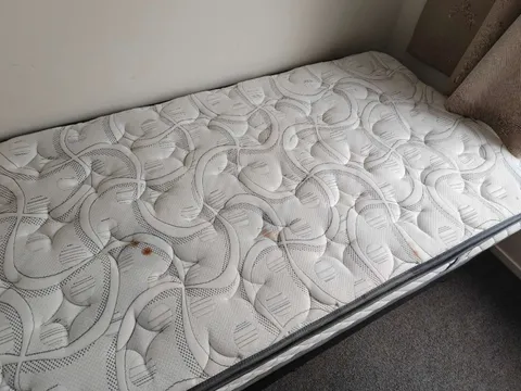 Patterned single mattress with several visible surface marks